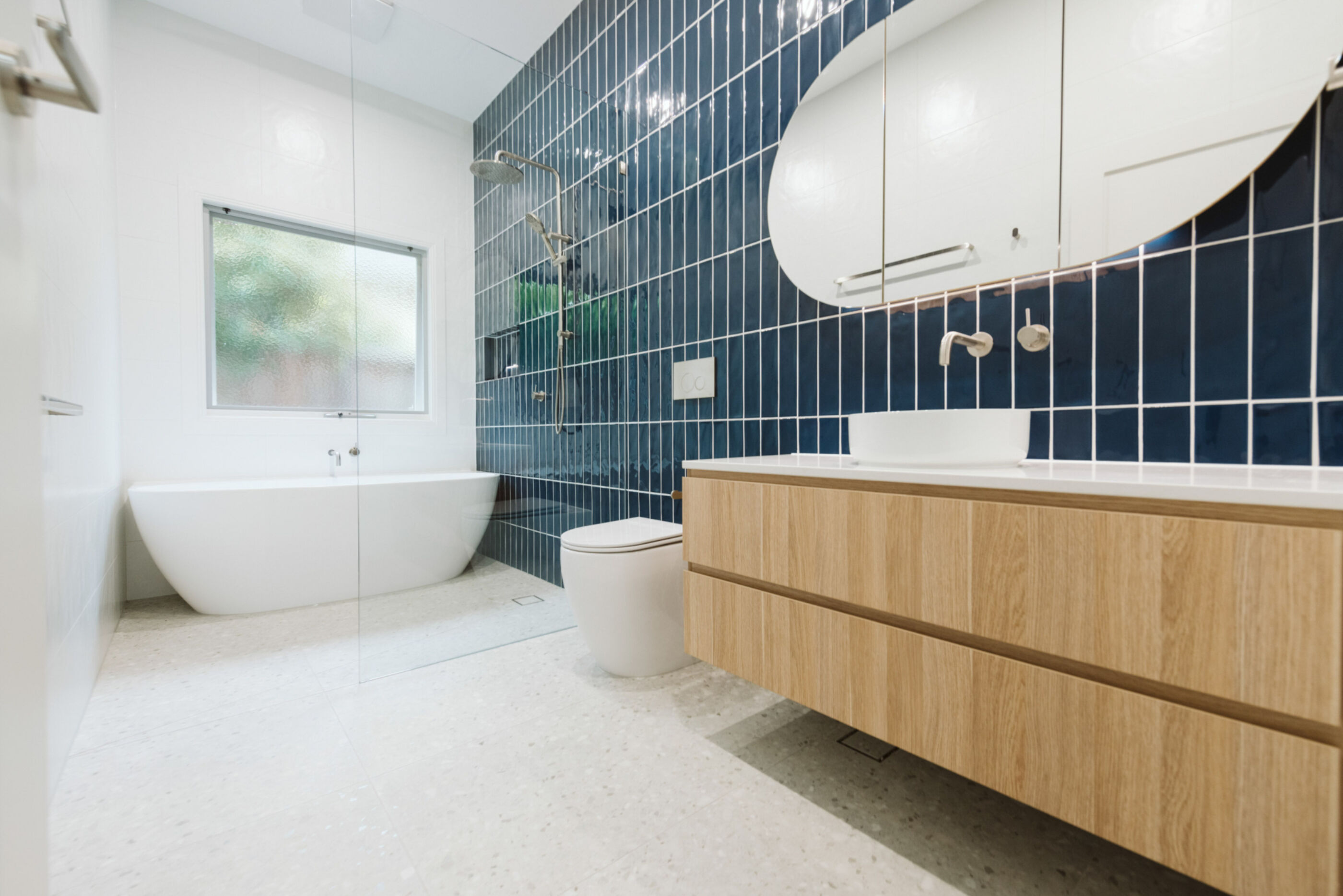 Modern bathroom with floating vanity, toilet and freestanding bath